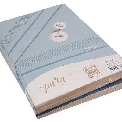 Jogo de lençóis azul claro com riscas e etiqueta da marca Pura