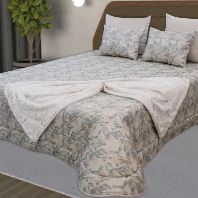 Cama com colcha e almofadas em tons pastel, colcha branca com detalhes dourados, cabeceira em vime e madeira, planta em fundo