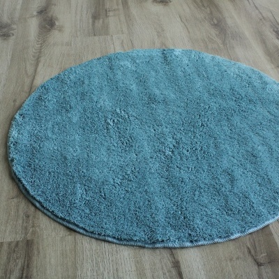 Tapete redondo azul claro sobre chão de madeira