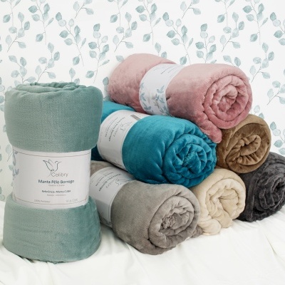 Sete mantas coloridas embaladas com faixa branca sobre superfície branca e papel de parede com folhas