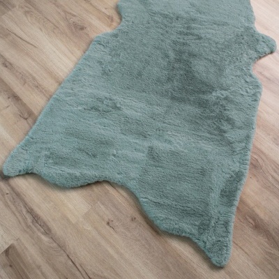 Tapete cinza claro peludo formato irregular em chão de madeira clara