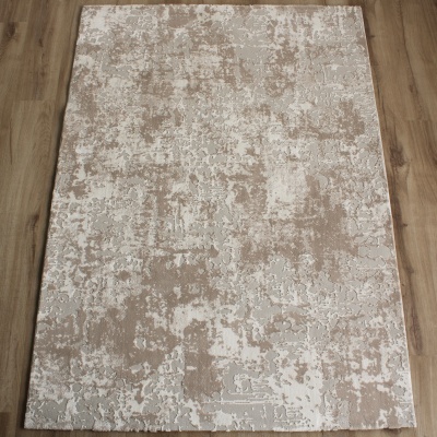 Tapete rectangular com padrão abstrato em bege, cinzento e branco sobre chão de madeira