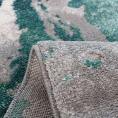 Tapete cinza e verde água com padrão abstrato e dobra mostrando o verso