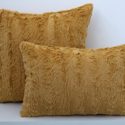Duas almofadas castanhas de tecido felpudo com textura. 