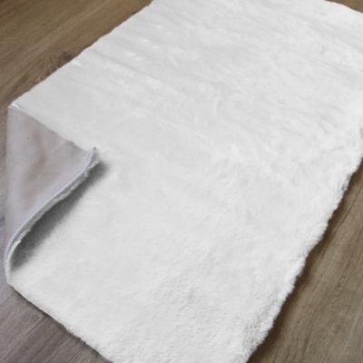 Tapete branco macio com verso cinzento em chão de madeira