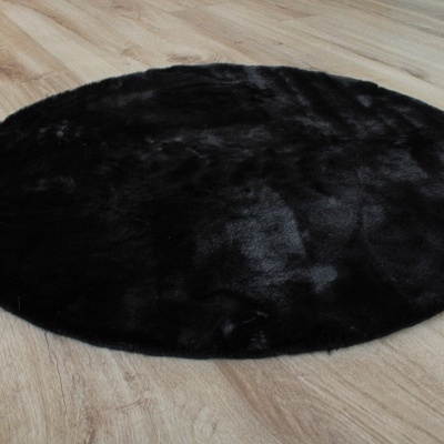 Tapete redondo preto felpudo em chão de madeira clara