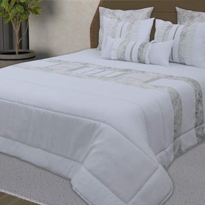 Cama com edredão branco com detalhes cinza e almofadas decorativas cinza e branco