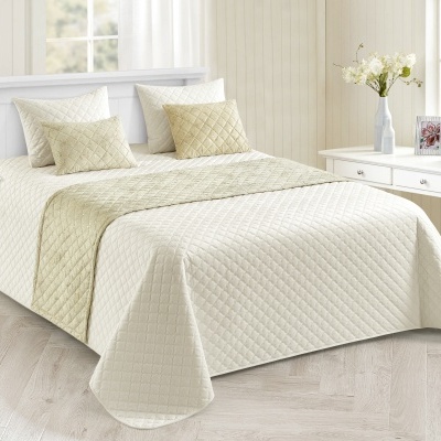 Conjunto de cama matelassado creme e bege claro num quarto minimalista