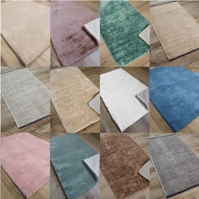 Conjunto de 12 tapetes de diferentes cores e texturas sobre chão de madeira.