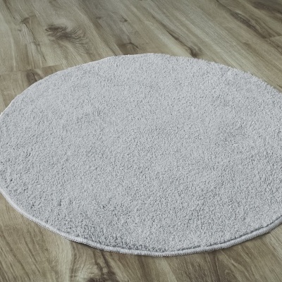 Tapete redondo cinza claro sobre chão de madeira clara