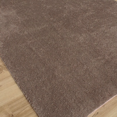 Tapete castanho claro macio sobre chão de madeira