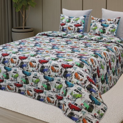 Colcha e almofadas com padrão de carrinhas coloridas num quarto moderno