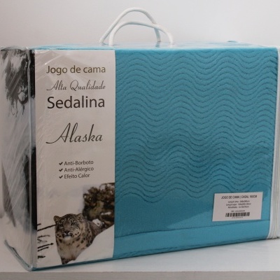 Embalagem de jogo de cama azul com padrão ondulado e texto de descrição em português