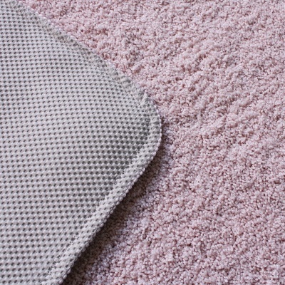 Tapete cor-de-rosa claro felpudo com canto de tapete cinzento em padrão malha