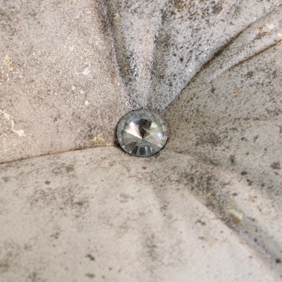 Estofado cinza com botão transparente central e manchas