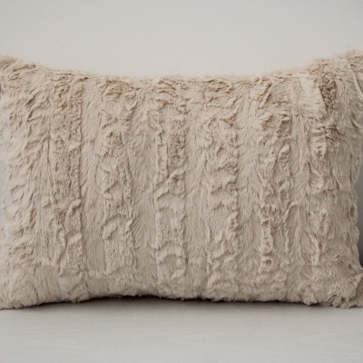 Almofada retangular de pelúcia creme com textura macia e padrão irregular