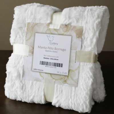 Manta branca de pelo sintético dobrada com etiqueta