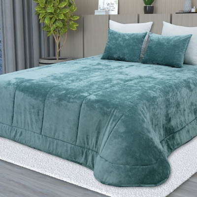 Cama com colcha felpuda verde-azulado e almofadas, ambiente moderno