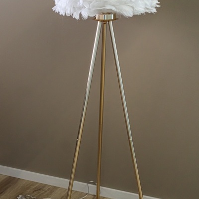 Lâmpada de pé com abajur de penas brancas e base metálica dourada tripé