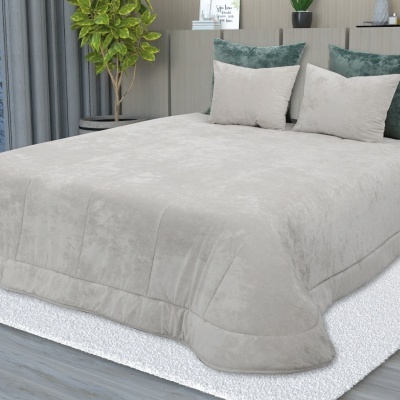 Cobertor bege claro macio em cama com almofadas verdes e bege, tapete branco e chão de madeira