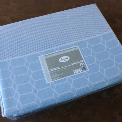 capa de edredão azul embalada com padrão geométrico e etiqueta