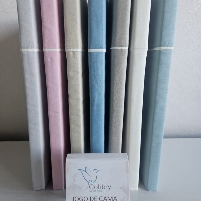 Pacotes de jogo de cama em várias cores pastel com etiqueta de marca e descrição na frente