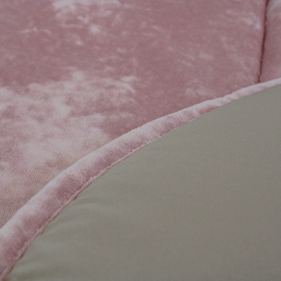 Detalhe de tecido rosa aveludado com borda curva e material cinzento-bege