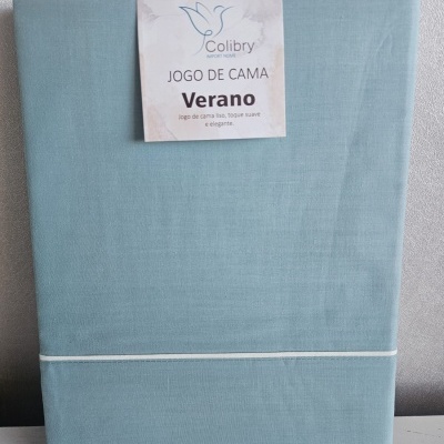 Conjunto de roupa de cama azul claro da marca Colibry com etiqueta Jogo de Cama Verano