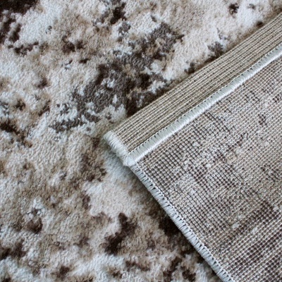 Tapete cinza e branco com borda dobrada mostrando o verso