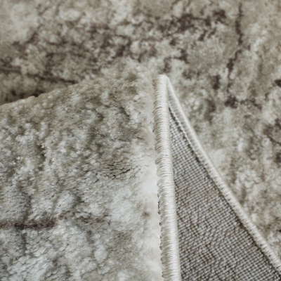 Tapete felpudo cinza com padrão abstrato e bordas costuradas