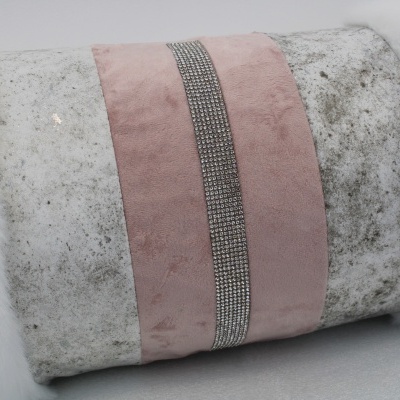 Almofada decorativa com textura branca felpuda e faixa rosa com pedraria prateada