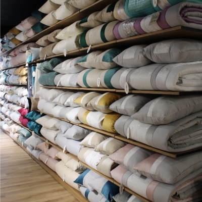 Prateleiras com edredões ou colchas armazenados em diversas cores e padrões simples