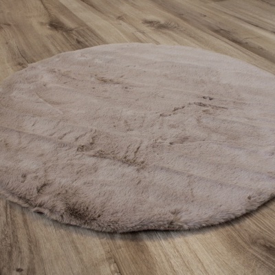 Tapete redondo cinza claro felpudo sobre pavimento de madeira clara