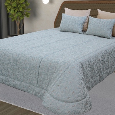 Cama com edredão azul claro estampado e almofadas retangulares no quarto