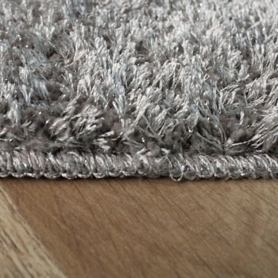 Tapete cinza felpudo sobre chão de madeira clara