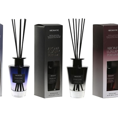 Três difusores de fragrância em vidro com palitos pretos e respetivas caixas coloridas