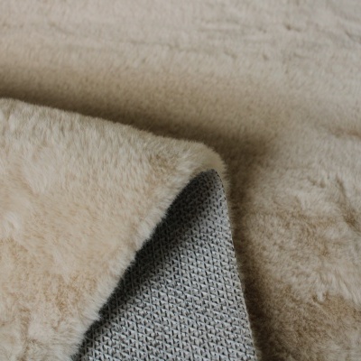 Tapete ou manta bege felpuda com underside cinza de tecido com padrão