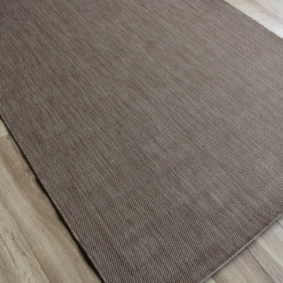 Tapete castanho sobre chão de madeira clara