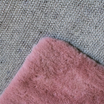 Tecido felpudo rosa sobre tecido cinza com padrão entrelaçado