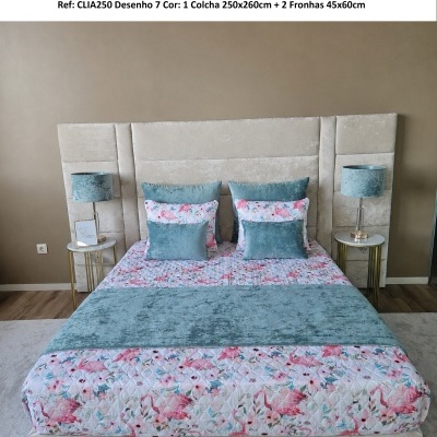 Conjunto cama com colcha de flamingos rosas, almofadas azuis, cabeceira bege e mesas com candeeiros azuis