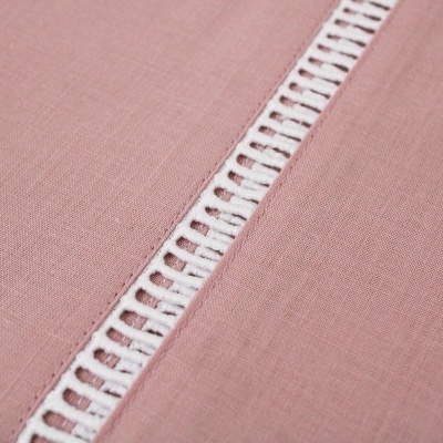 Tecido rosa com faixa decorativa branca com padrão de buracos