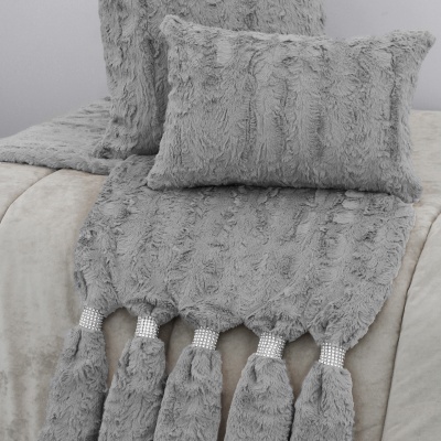 Almofadas e manta peluda cinzenta com franjas prateadas