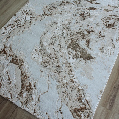 Tapete retangular abstrato em tons de bege e castanho sobre chão de madeira clara