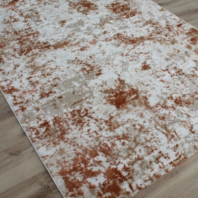 Tapete retangular em padrão abstrato branco, cinza e laranja sobre chão de madeira clara