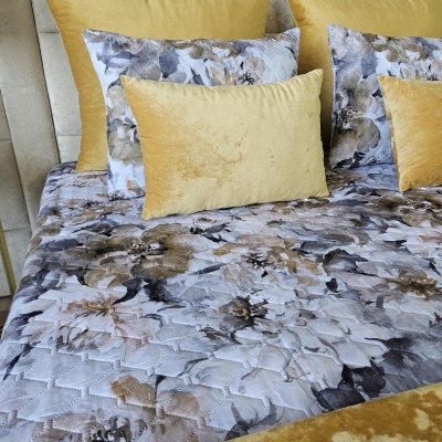 Cama com almofadas estampadas florais e almofadas amarelas aveludadas