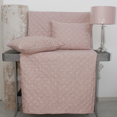 Conjunto de almofadas e capa de sofá rosa com padrão matelassê, móvel cinzento, rolo de tapete bege, lâmpada com cúpula rosa