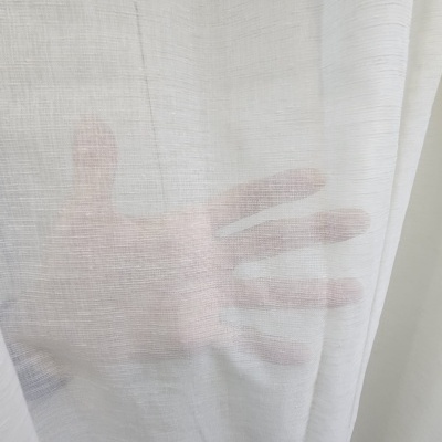 Cortina branca transparente com mão visível por trás
