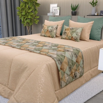 Cama com edredão bege e almofadas com padrão geométrico em tons verde e bege