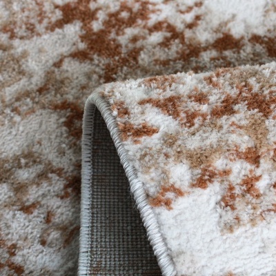 Tapete felpudo castanho, bege e branco com padrão abstrato