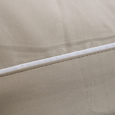 Tecido bege com costura reta e fita branca